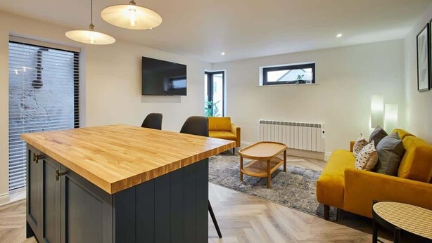 Un salon moderne avec une table à manger en bois, un canapé et une table basse.