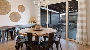 A modern dining area with a round wooden table, black chairs, and a hanging light fixture. - Private Pool Oasis #57: Private Pool/Hot Tub, community pool, splashpad, Pickleb (Santa Clara)