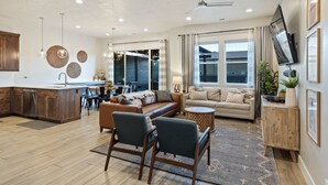 A spacious living area with a sofa, chairs, a coffee table, and a TV mounted on the wall. - Private Pool Oasis #57: Private Pool/Hot Tub, community pool, splashpad, Pickleb (Santa Clara)