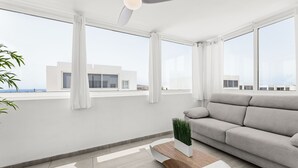 Ein modernes Wohnzimmer mit einem grauen Sofa, einem Holztisch und einer Topfpflanze.