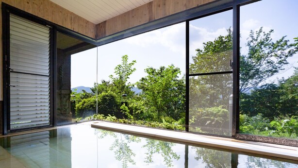 A modern interior with large glass windows, a reflective floor, and a view of lush greenery outside. - Hakone Ashinoko Bikeikan (Hakone)