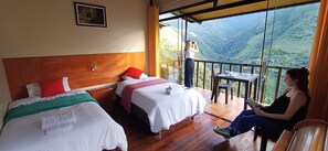 A hotel room with two beds, a balcony, and a view of a mountainous landscape. - Ecoterra Inka Lodge (Santa Ana)
