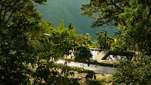 Ein friedlicher See mit einer Steinbrücke und üppiger Vegetation.