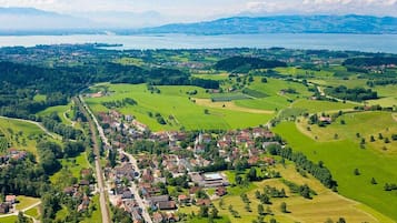 Vista aérea de un pueblo con un río, campos verdes y una iglesia.
