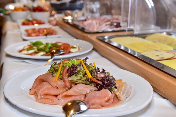 A buffet with various dishes including smoked salmon, salads, and other prepared foods. - Hotel-Gasthof Adler (Lindau)