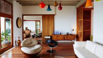 Un salon moderne avec un canapé blanc, un fauteuil rond et un meuble en bois.