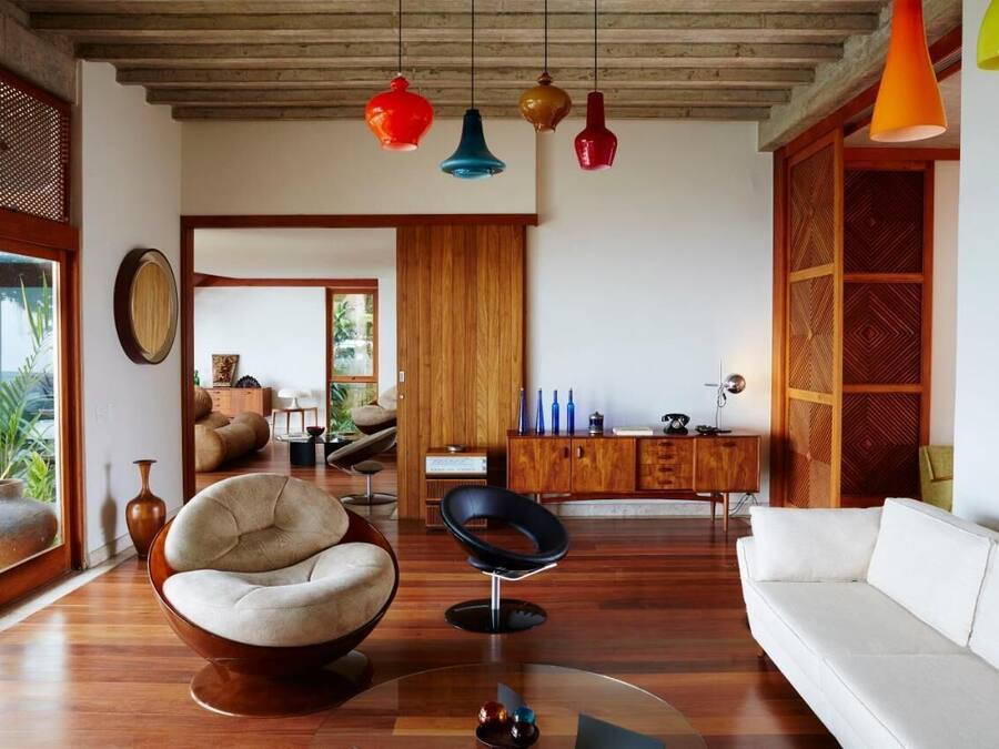 Un salon moderne avec un canapé blanc, un fauteuil rond et un meuble en bois.