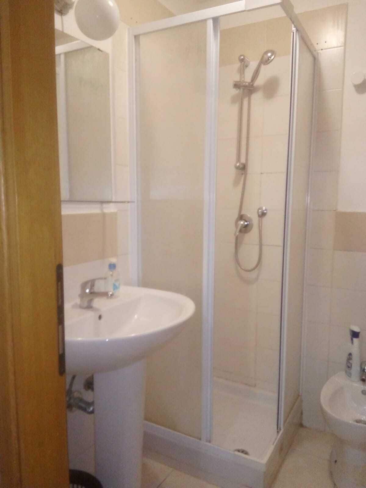 Un baño con ducha, lavamanos y bidé.