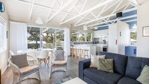 Een moderne woonkamer met een bank, stoelen en een eethoek.