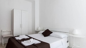 A hotel room with a bed, a wardrobe, a small table, and a chair. - Studio 3 at the Colosseum (Roma)