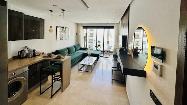 A modern living space with a kitchen, dining area, and seating area. - Stay'Inn - Stadium Penthouse (Casablanca)