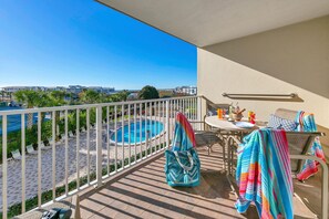 Un balcon avec piscine, un espace salon extérieur et une vue sur l’océan.