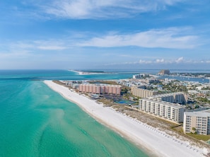 A coastal hotel with multiple buildings, a beach, and a marina.