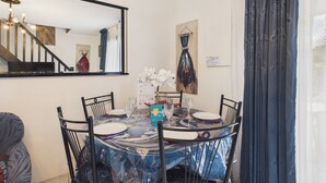 A dining area with a round table, chairs, a mirror, and a painting on the wall. - La Tranche-sur-Mer, house for 3 adults / 2 children (La Tranche-sur-Mer)