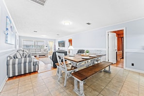 Un grand espace de vie comprenant une table à manger, un canapé et un banc.