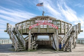 Eine Holzsteg-Konstruktion mit einem Schild, auf dem steht: "I Caught Mine at Cherry Grove Fishing Pier".