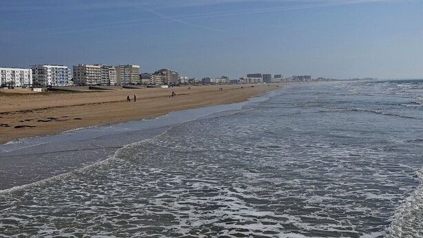 Una playa con edificios al fondo.