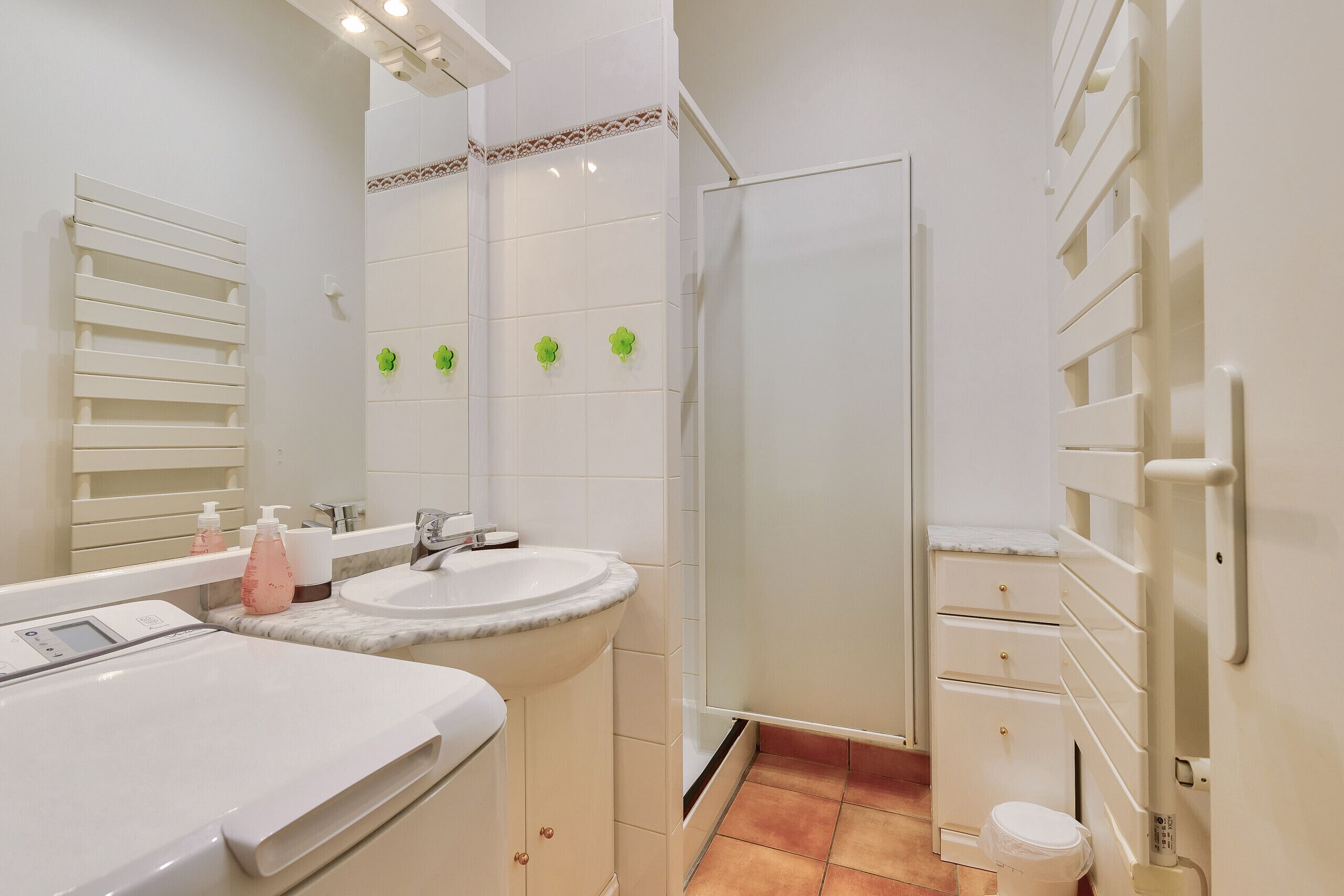 A bathroom with a double sink, a mirror, a shower enclosure, and a toilet.