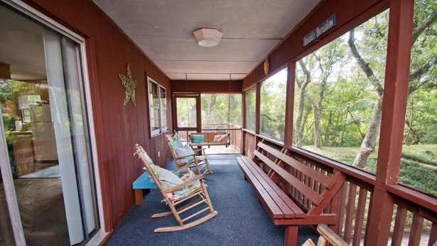 A covered porch with rocking chairs and benches, a wooden ceiling, and a view of trees. - Hasell Cottage, Oceanside House in Emerald Isle, NC! (Emerald Isle)