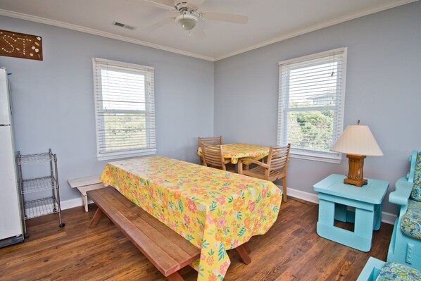 A bedroom with a bed, a desk, a chair, a lamp, and a window. - Hurst Cottage, Oceanfront House in Emerald Isle, NC! (Emerald Isle)