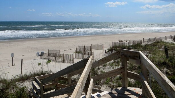 A beach with wooden boardwalks leading to the shore, sandy beach, and ocean waves. - Island Beach Racquet Club 303A, Oceanfront Condo in Atlantic Beach, NC! (Atlantic Beach)