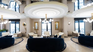 A spacious lobby with a central seating area, large windows, and a modern chandelier. - Aliba Hotel  (Edirne)