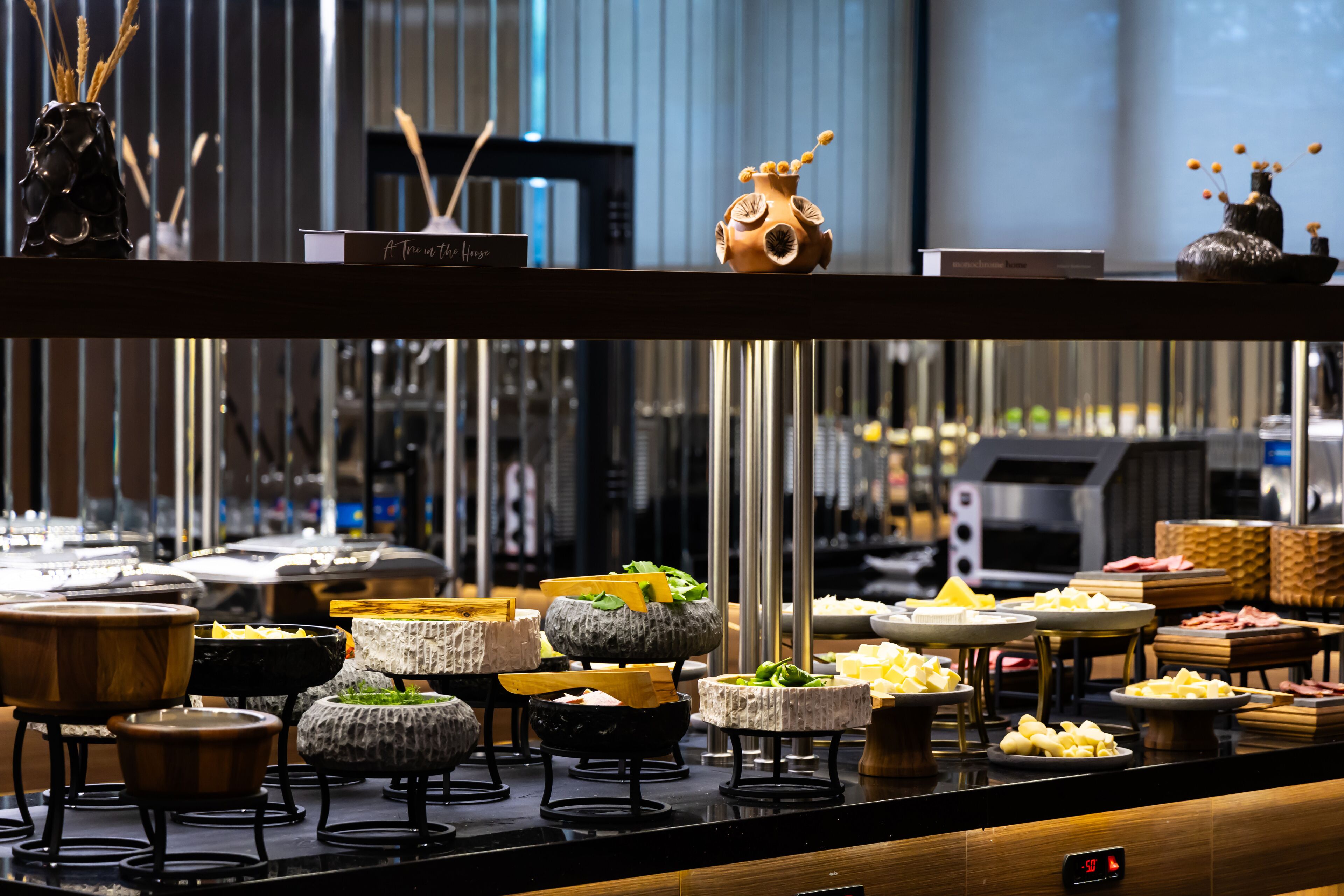 A buffet with various food items and decorative vases.