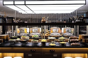 A buffet setup with multiple food stations, including a variety of dishes and a central decorative element.