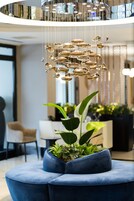 A modern interior with a blue seating area, a hanging light fixture, and a potted plant.
