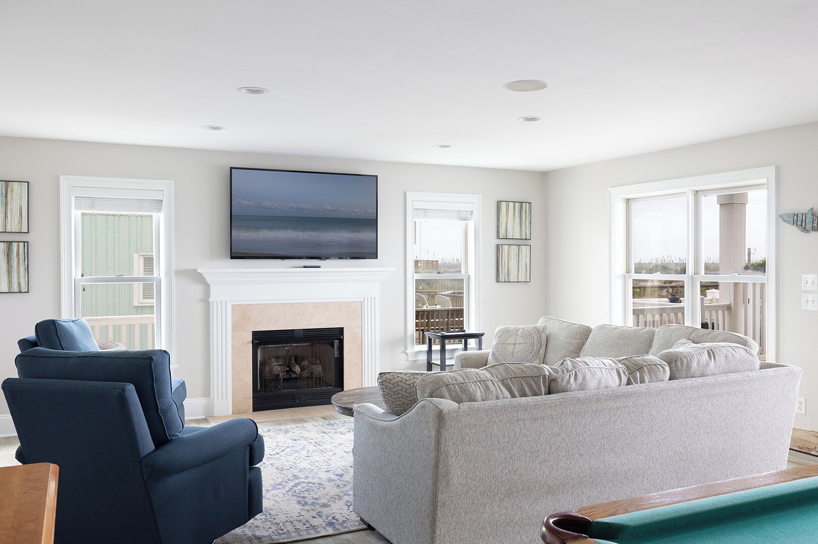 A living room with a fireplace, a television, and a view of the outdoors.