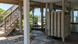 Un escalier en bois mène à un espace abrité d’où l’on peut admirer la mer.