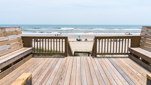 Un pontile di legno che conduce a una spiaggia con vista sull'oceano.