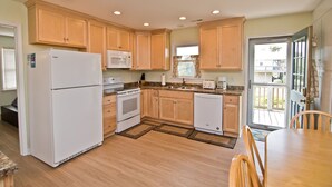 A kitchen with wooden cabinets, a refrigerator, a microwave, a stove, and a dishwasher. - Nuthin But Sun, Almost Oceanfront House in Emerald Isle, NC! (Emerald Isle)