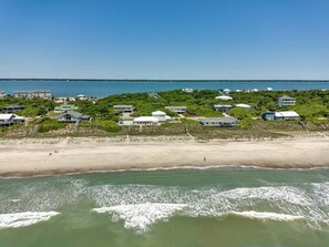 A coastal area with a beach and several buildings, likely a resort or hotel.