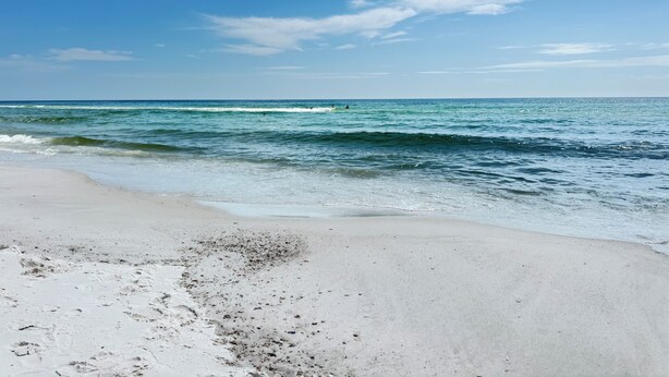 A beach with clear skies and calm waves. - Tigh Na Mara is a Porch Lover’s Paradise in Orange Beach, AL (Orange Beach)