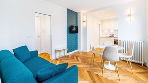 A modern apartment with a living room, dining area, and kitchen.