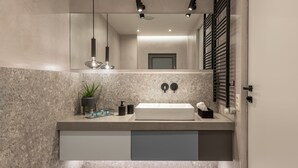 A modern bathroom with a marble countertop, a large mirror, a toilet, and a sink with a faucet. - Arca A1 Junior Suite (Athens)