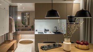 Una cocina moderna con una isla central, un comedor con mesa de madera y un espejo grande.