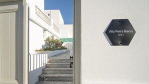 Eine Treppe führt zu einem weißen Gebäude mit dem Schild "Villa Pietra Bianca 1891".