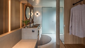 A modern bathroom with a large mirror, a sink, and a towel rack. - Porfyra B2 Master Suite (Athens)