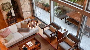 Una sala de estar moderna con un gran ventanal, un sofá, sillones y una mesa de centro.