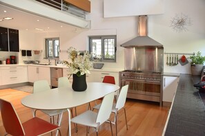 Enjoy cooking in this well-lit kitchen with a central island, oven, and stainless steel range hood.