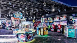 Una sala giochi al coperto con diverse macchine da gioco e un cartello con scritto 'Harbor of Loon'.