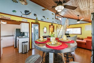A dining area with a round table, chairs, and a ceiling fan.