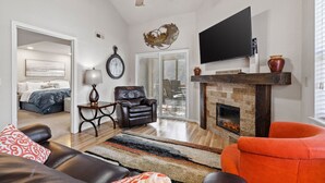 A living room with a fireplace, leather sofas, a flat-screen TV, and a ceiling fan. - Conveniently located with great views, but close to all the action! (Branson)