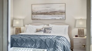 A neatly arranged bedroom with a bed, two bedside tables, and a wall-mounted painting. - Conveniently located with great views, but close to all the action! (Branson)