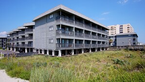 A multi-story hotel with balconies, located near a beach. - Cute condo rental at family-friendly resort - secluded condos with pool (North Myrtle Beach)