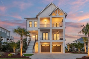 A multi-story residential building with a central staircase, balconies, and a garage.
