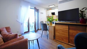 A modern living room with a sofa, a dining table, and a TV. - Spacious holiday homes with terraces, Mielenko (Mielenko)