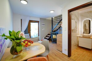 Ein modernes Interieur mit Essbereich, Treppe und Badezimmer.